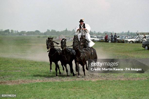 A HORSEMAN DEMONSTRATES HIS SKILLS TO THE QUEEN AND DUKE OF EDINBURGH WHEN THEY VISITED BUGAC ON THE HUNGARIAN PLAINS.