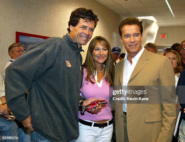 Arnold Schwarzenegger poses with Winston Cup driver Michael Waltrip and wife, Buffy.