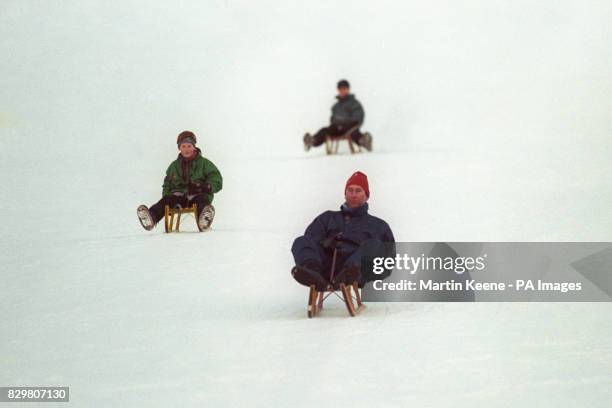 THE PRINCE OF WALES IS FOLLOWED BY HIS SONS, PRINCE HARRY [L] & PRINCE WILLIAM, DURING A TOBOGGAN RACE ON THE SLOPES OUTSIDE THEIR HOTEL IN THE SWISS...