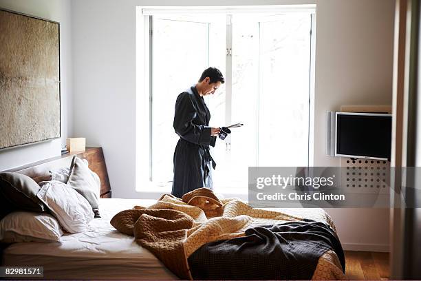 man in luxury bedroom, bathrobe, morning - read and newspaper and bed stock pictures, royalty-free photos & images