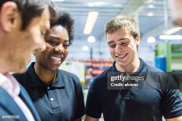 worker in meeting with colleagues at factory - uniform worker stock pictures, royalty-free photos & images