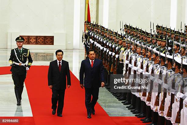 Chinese President Hu Jintao accompanies Venezuelan President Hugo Chavez to view an honour guard during a welcoming ceremony inside the Great Hall of...