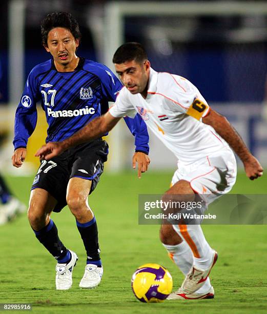 Hideo Hashimoto of Gamba Osaka and Hassan Abbas of Al Karama compete for the ball during Asia Champions League quarter final 2nd leg match between...