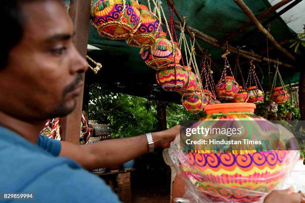 An artist checks a decorative earthern pots ahead of Dahi Handi Festival at Vashi, on August 10, 2017 in Mumbai, India. Dahi Handi is one of the...