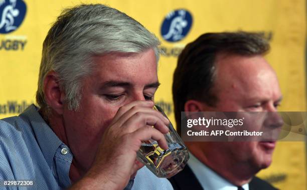 Australian Rugby Union chairman Cameron Clyne drinks water as Bill Pulver, CEO of the ARU, answers a question at a press conference at ARU...