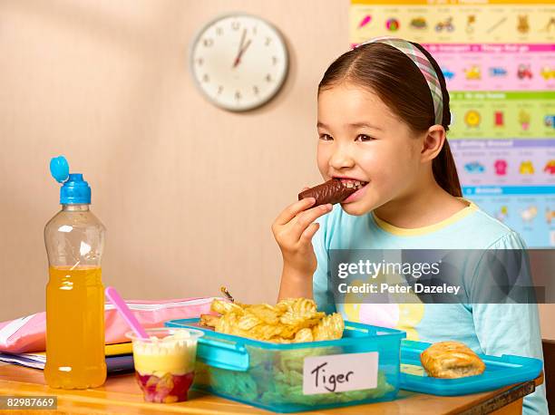 mixed race school girl eating junk food - sack lunch stock pictures, royalty-free photos & images