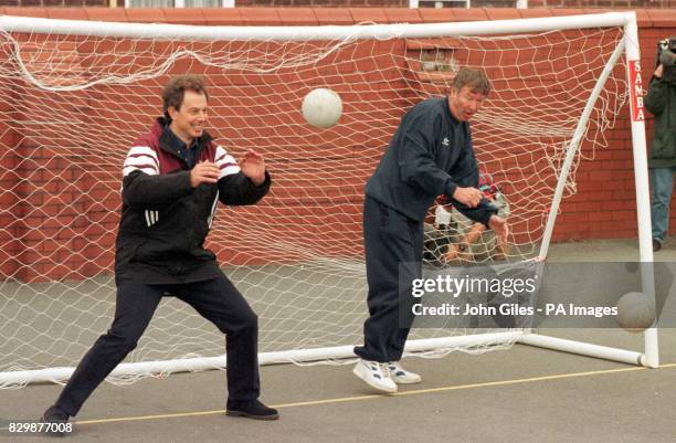 Labour leader Tony Blair parries a shot at goal as Manchester United manager Alex Ferguson attempts a save during a visit today to Devonshire Road...