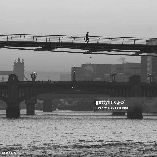 lone runner on the millennium bridge in a early morning - millennium bridge londra foto e immagini stock