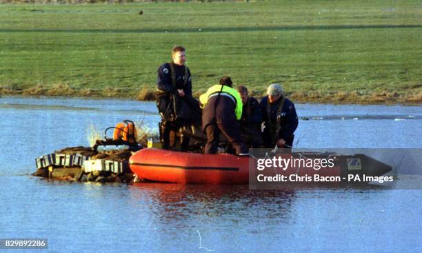 Police frogmen lower the body of a boy into a boat, who slipped under the ice on a pond at the Auchinhavie Golf Course near Irvine today . See PA...