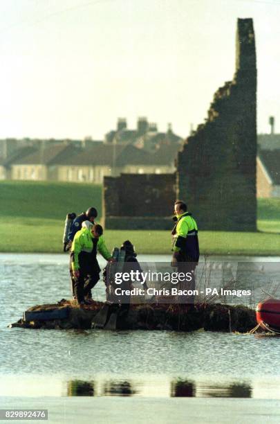 Police frogmen search for the body of a boy who slipped under the ice on a pond at the Auchinhavie Golf Course near Irvine today . Photo by Chris...