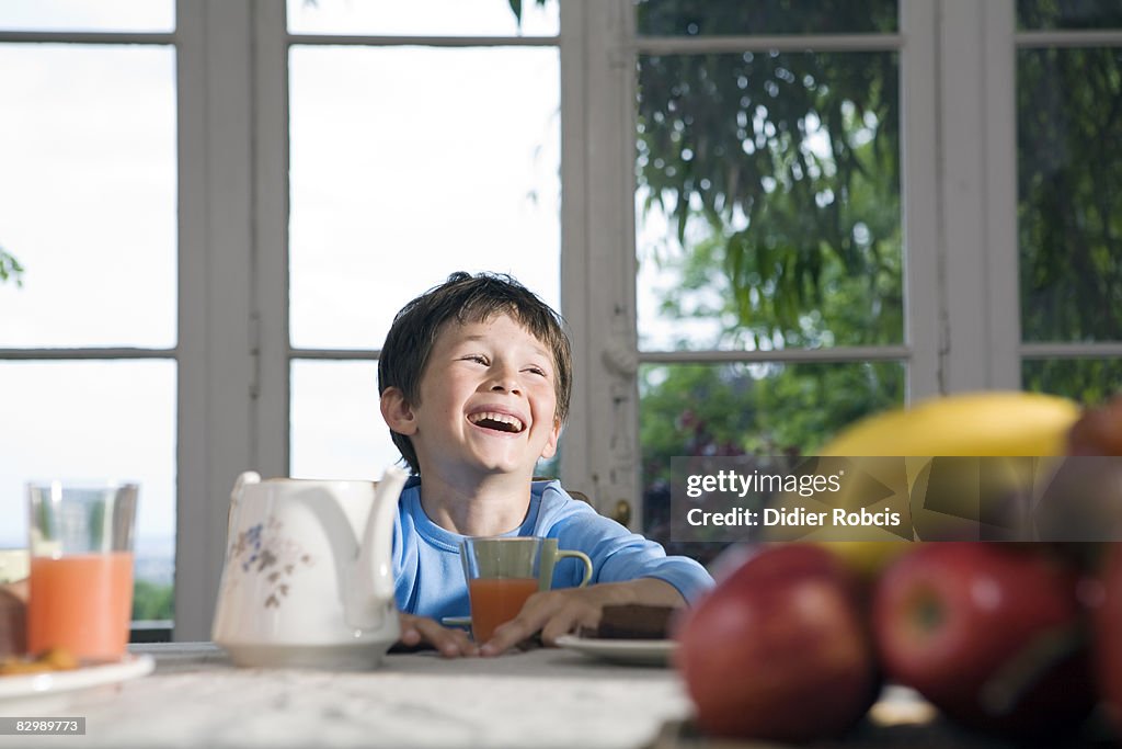 Boy laughs during breakfast