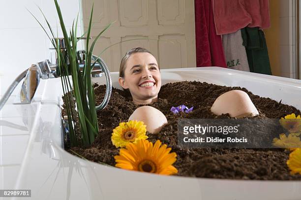 woman bathes in dirt - schlammbad stock-fotos und bilder