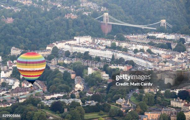 Hot air balloon flies over the Clifton Suspension bridge as they take to the skies as they participate in the mass assent at sunrise on the second...