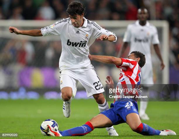 Miguel Torres of Real Madrid duels for the ball with David Barral of Real Sporting de Gijon during the La Liga match between Real Madrid and Real...
