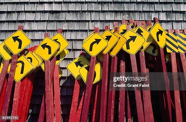 traffic directions signs leaning on shed - double arrow stock pictures, royalty-free photos & images