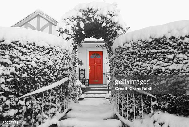snowy view of house with red door - red grant stock-fotos und bilder