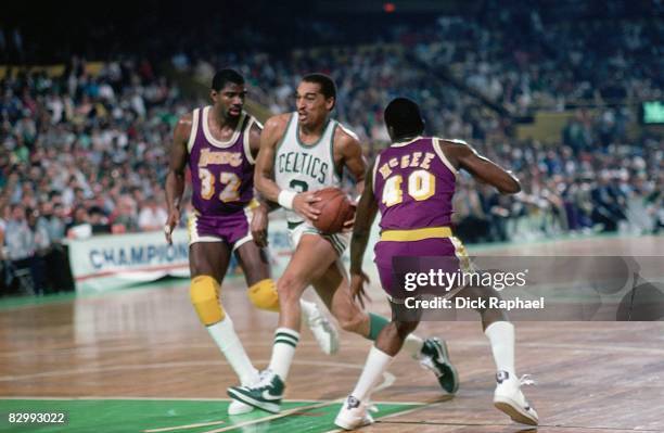 Dennis Johnson of the Boston Celtics drives to the basket between Magic Johnson and Mike McGee of the Los Angeles Lakers in Game One of the 1985 NBA...