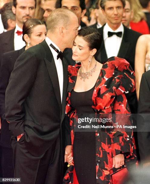 Bruce Willis and wife Demi Moore arrive for the premiere of the Fifth Element at the 50th Cannes Film Festival.