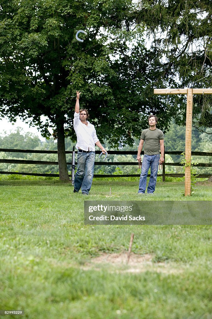 Two men playing horseshoes