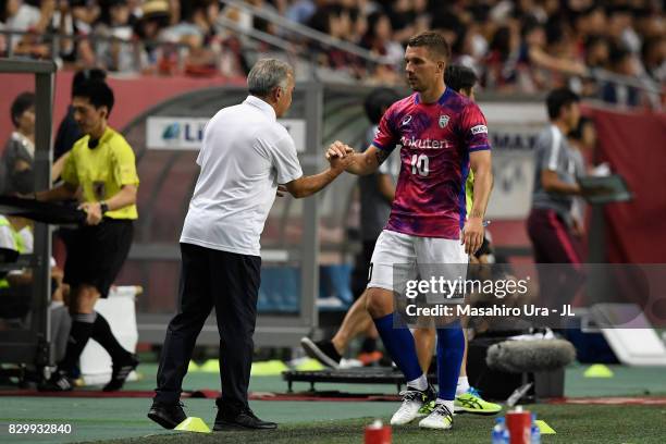 Lukas Podolski of Vissel Kobe shakes hands with head coach Nelsinho after substituted during the J.League J1 match between Vissel Kobe and Kashima...