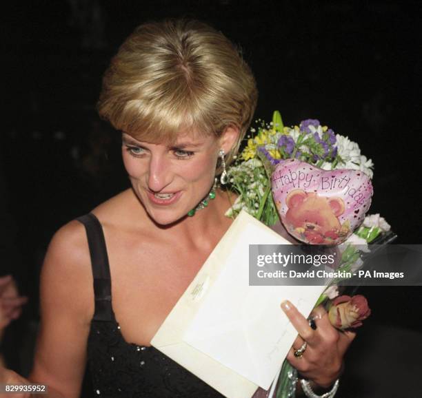 Diana, Princess of Wales, leaves the Tate Gallery's Centenary Gala Dinner carrying birthday gifts she received from friends for her 36th birthday.