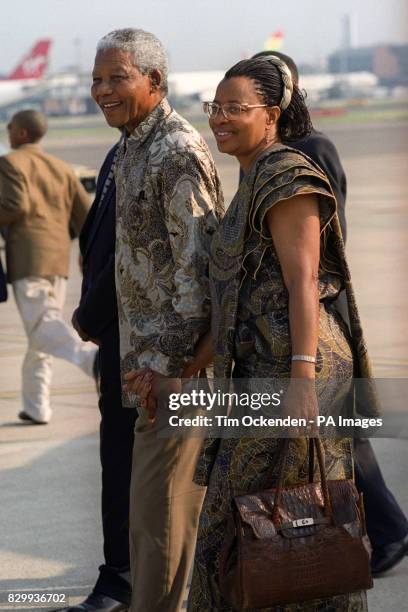 South African President Nelson Mandela arrived at Heathrow airport with the woman who has replaced his ex-wife Winnie, grinning at suggestions he was...