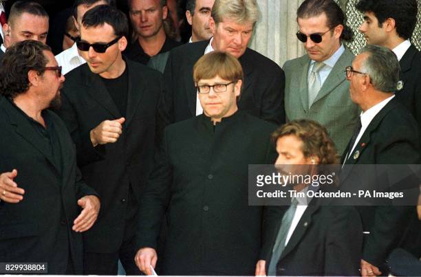 Singer Elton John leaves the memorial service for murdered fashion designer Gianni Versace with his partner David Furnish in Milan, Italy.