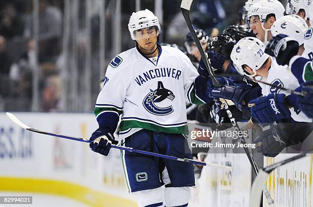 Jason Krog of the Vancouver Canucks skates by the Vancouver bench after scoring a shoot-out goal against the Edmonton Oilers during an NHL preseason...