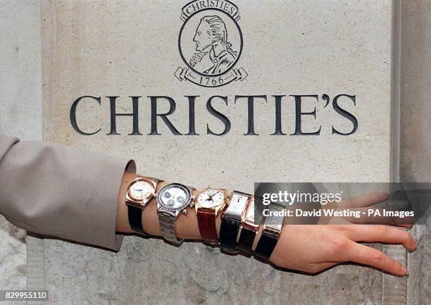 An employee at Christie's Auction House in London today models six watches from a private collection of over 300 Rolex watches - the largest...