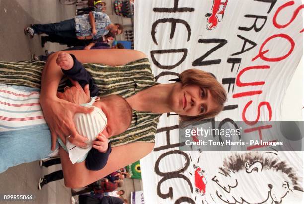 Mother clasps a smog mask to her baby's face during a protest rally in Trafalgar Square, London today to demand a Government act to cut traffic...