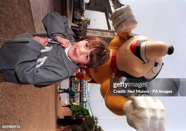 Young Lachlan Murphy battles to keep hold of a giant inflatable of the cartoon character, 'Mighty Mouse', as it towers over central London this...