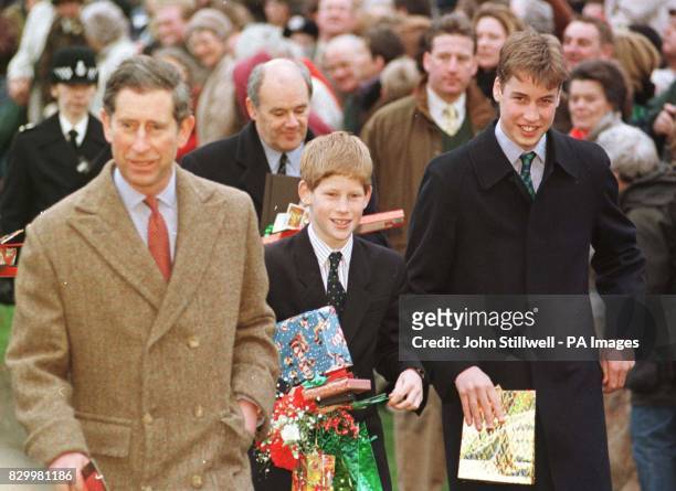 Princes William and Harry, clutch gifts from wellwishers as they leave Sandringham Church with their father, Prince Charles, after attending morning...
