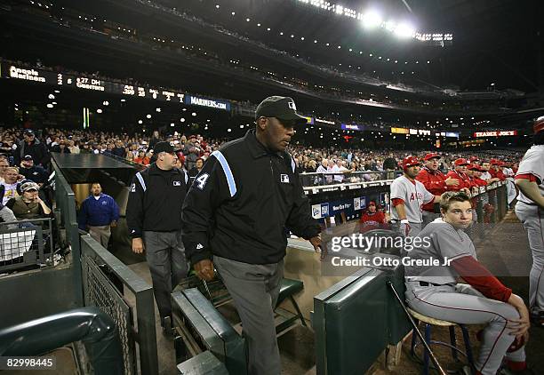 Umpires Chuck Meriwether, and Bill Welke emerge from the tunnel after having reviewed a call on replay for the first time in Mariners history during...