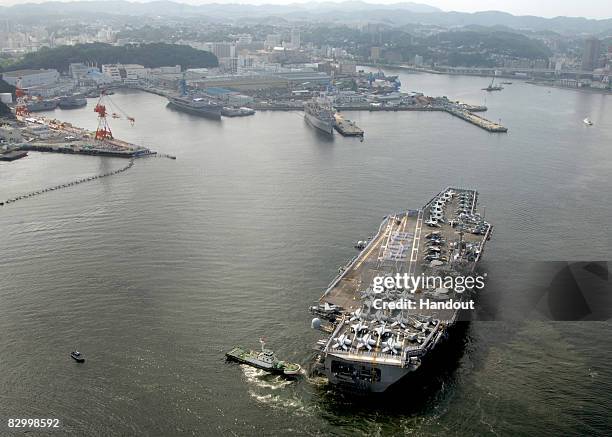 Sailors aboard the aircraft carrier USS George Washington form the phrase "Hajimemashite," which means "nice to meet you" in Japanese, as they arrive...