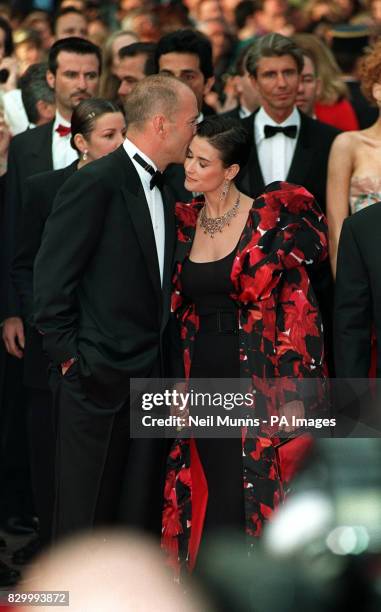 Bruce Willis kisses his wife Demi Moore arrive for the premiere of the Fifth Element at the 50th Cannes Film Festival.