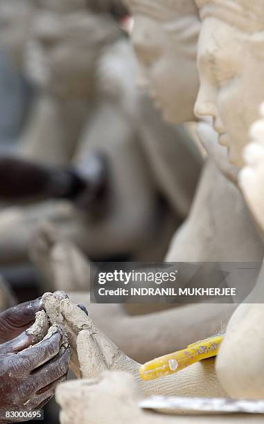 An artisan finishes up a plaster cast idol of the Hindu goddess Durga ahead of the upcoming festival of Navratri in Mumbai on September 25, 2008....