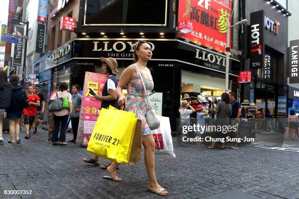 Pedestrians walk past at the Myeongdong shopping district on August 11, 2017 in Seoul, South Korea. North Korea have announced they are preparing to...