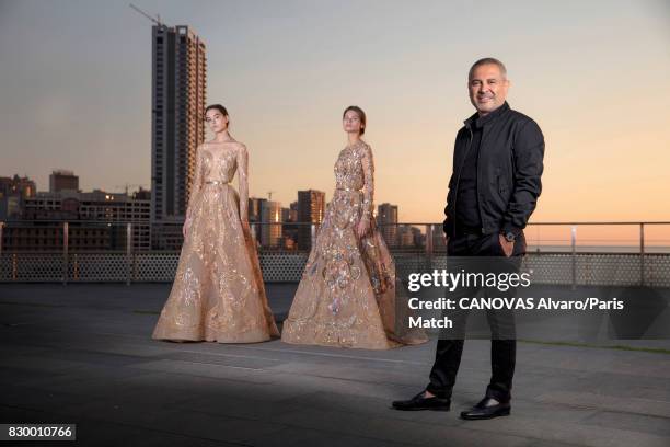 Fashion designer Elie Saab with 2 models wearing clothes from of his new collection are photographed for Paris Match on June 24, 2017 in Beirut,...