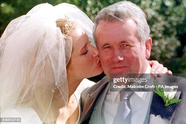 Martin Bell receives a kiss from his daughter Melissa after she married Peter Bracken at St. Oswald's Church, Lower Peover, Cheshire today . Photo by...