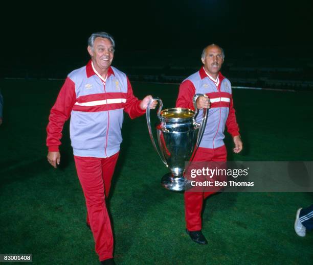 Liverpool manager Joe Fagan and his assistant Ronnie Moran proudly carry the trophy after Liverpool had beaten AS Roma in the European Cup Final at...