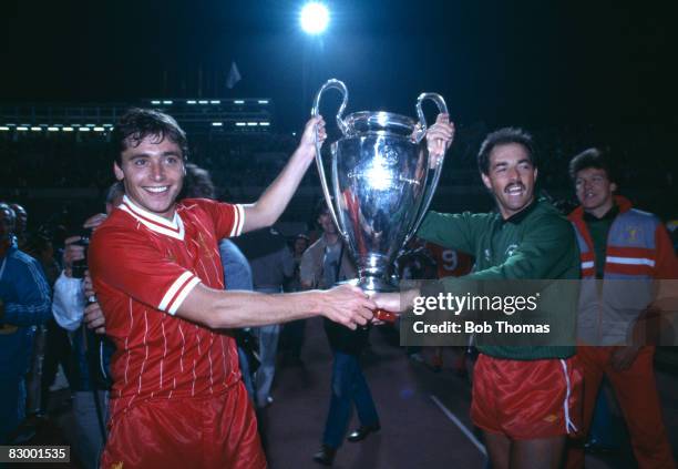 Liverpool goalkeeper Bruce Grobbelaar and striker Michael Robinson carry the European Cup on the lap of honour after defeating AS Roma in the Final...