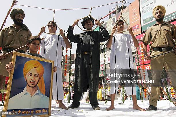 Indian Sikh youths dressed as Indian freedom fighter Bhagat Singh , with accomplices Shivaram Rajguru and Sukhdev Thapar , hold up nooses during a...