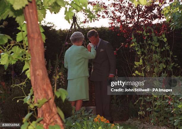 The Queen is greeted by her eldest son, Prince Charles, in 'Impressions of Highgrove, ' an exhibit based on the organic garden at Highgrove House,...