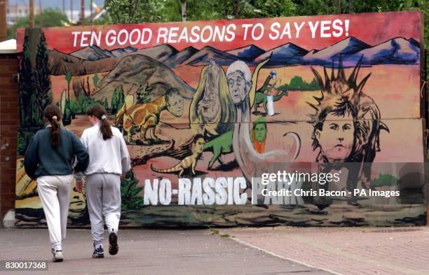 Two young girls walk past a mural in the Falls Road, Belfast, giving reasons to vote Yes in the Northern Ireland referendum. EDI Photo by Chris...