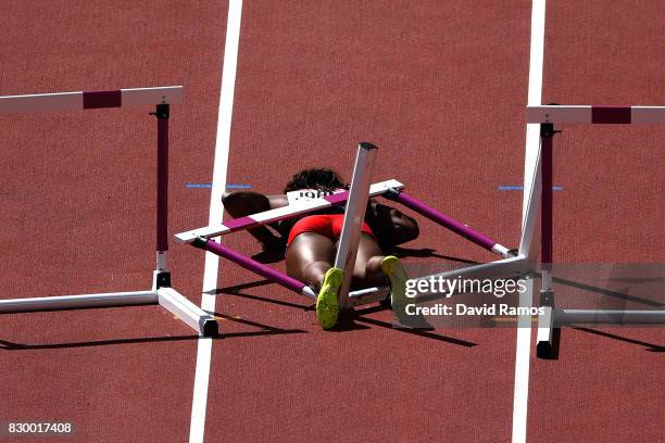 Deborah John of Trinidad and Tobago falls as she competes in the Women's 100 metres hurdles heats during day eight of the 16th IAAF World Athletics...