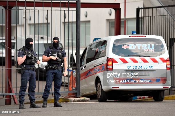 An ambulance enters as French special police officers stand guard at the entrance of the Georges Pompidou Hospital in Paris, on August 11 where the...