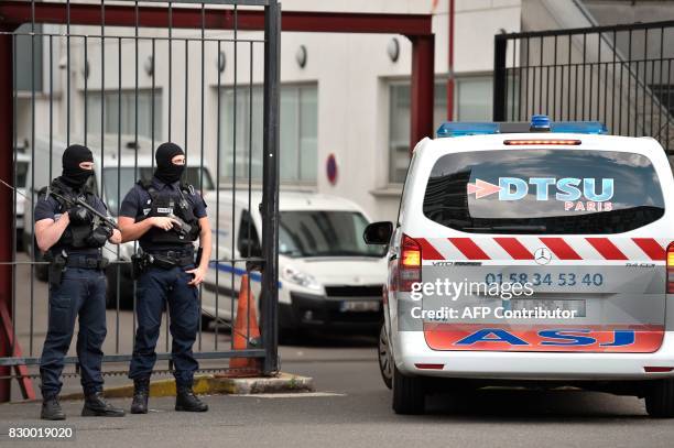 An ambulance enters as French special police officers stand guard at the entrance of the Georges Pompidou Hospital in Paris, on August 11 where the...