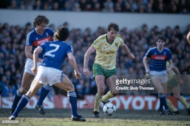 Norwich City striker Mike Channon on the ball, surrounded by Ipswich Town defenders Terry Butcher and George Burley during the Football League Milk...