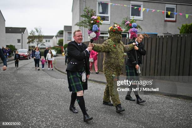 Burryman Andrew Taylor meets residents as he parades through the town encased in burrs on August 11, 2017 in South Queensferry, Scotland. The parade...