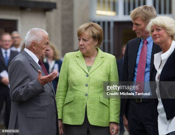 German Chancellor Angela Merkel speaks with former Prisoner Arno Defke as she visits the former prison of the East German, communist-era secret...